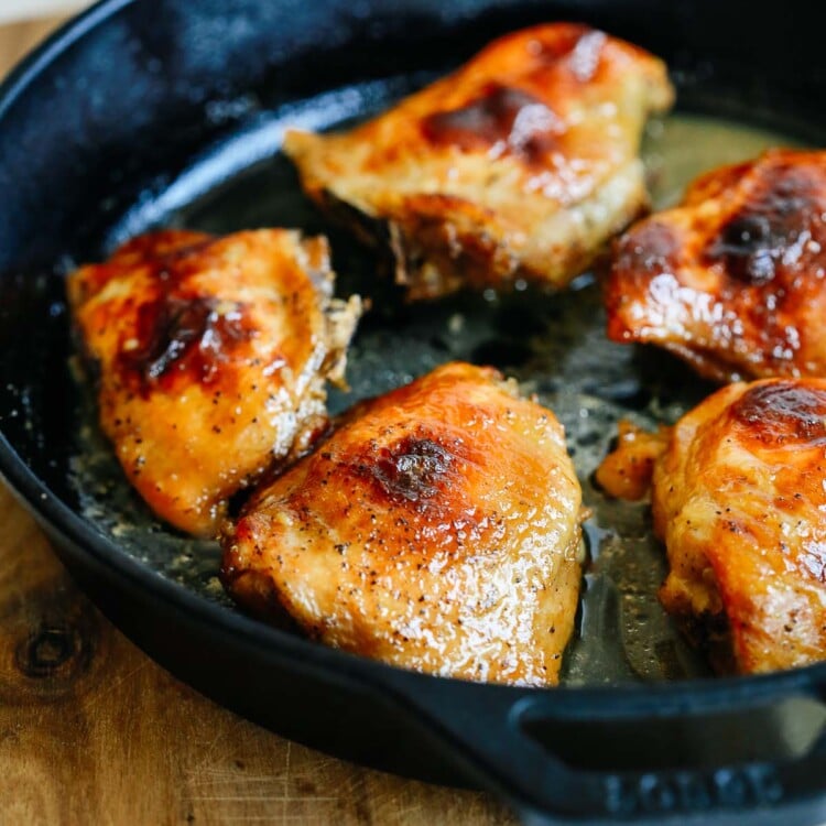 close up chicken thighs in a cast iron skillet