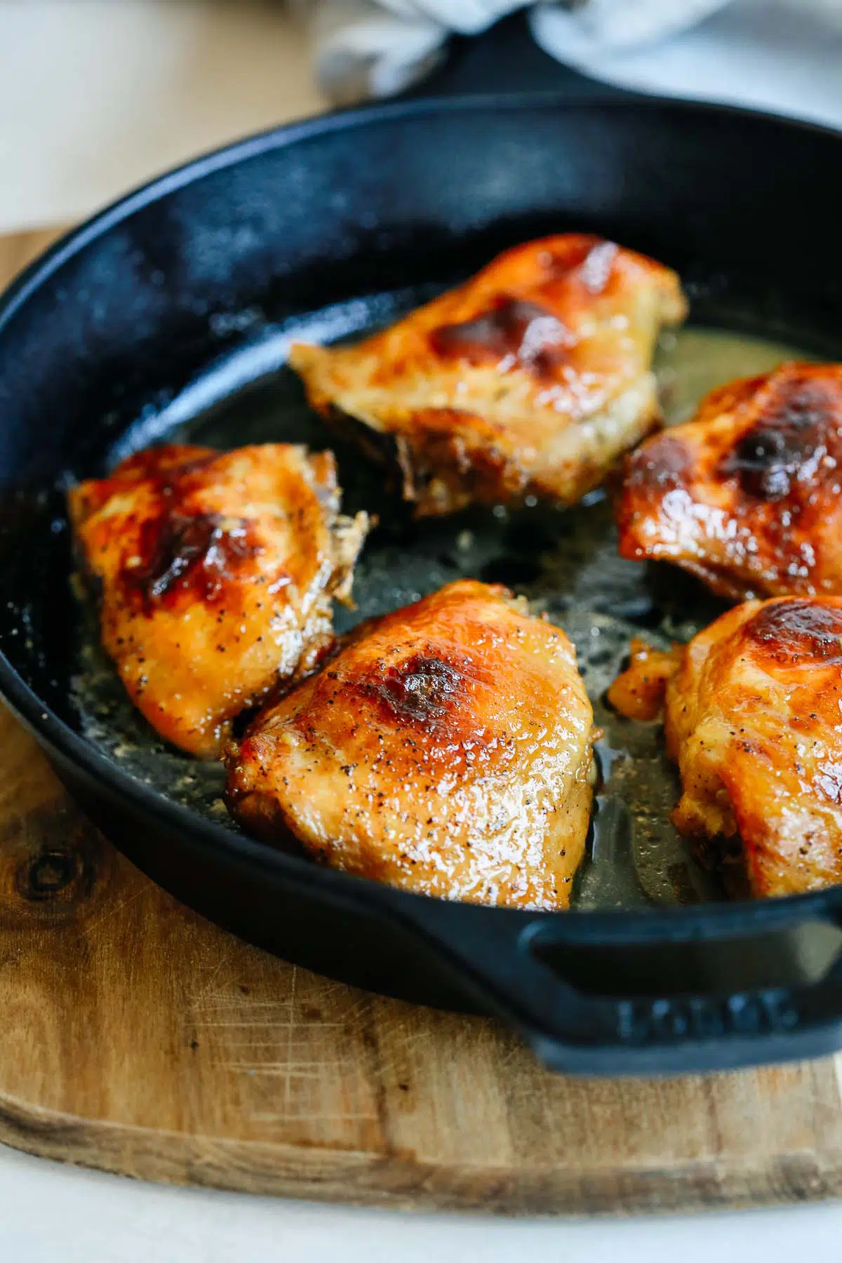 close up chicken thighs in a cast iron skillet 