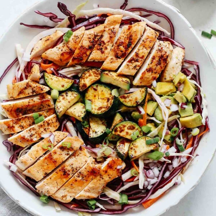 Overhead shot of cabbage salad with grilled chicken.