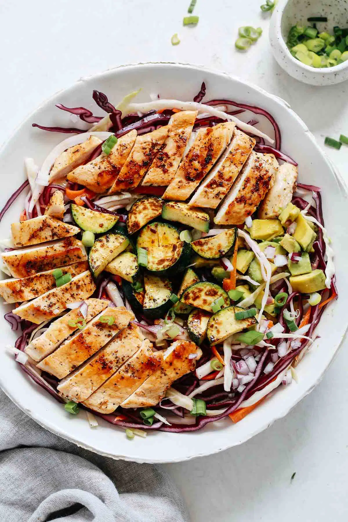 Overhead shot of cabbage salad with grilled chicken.