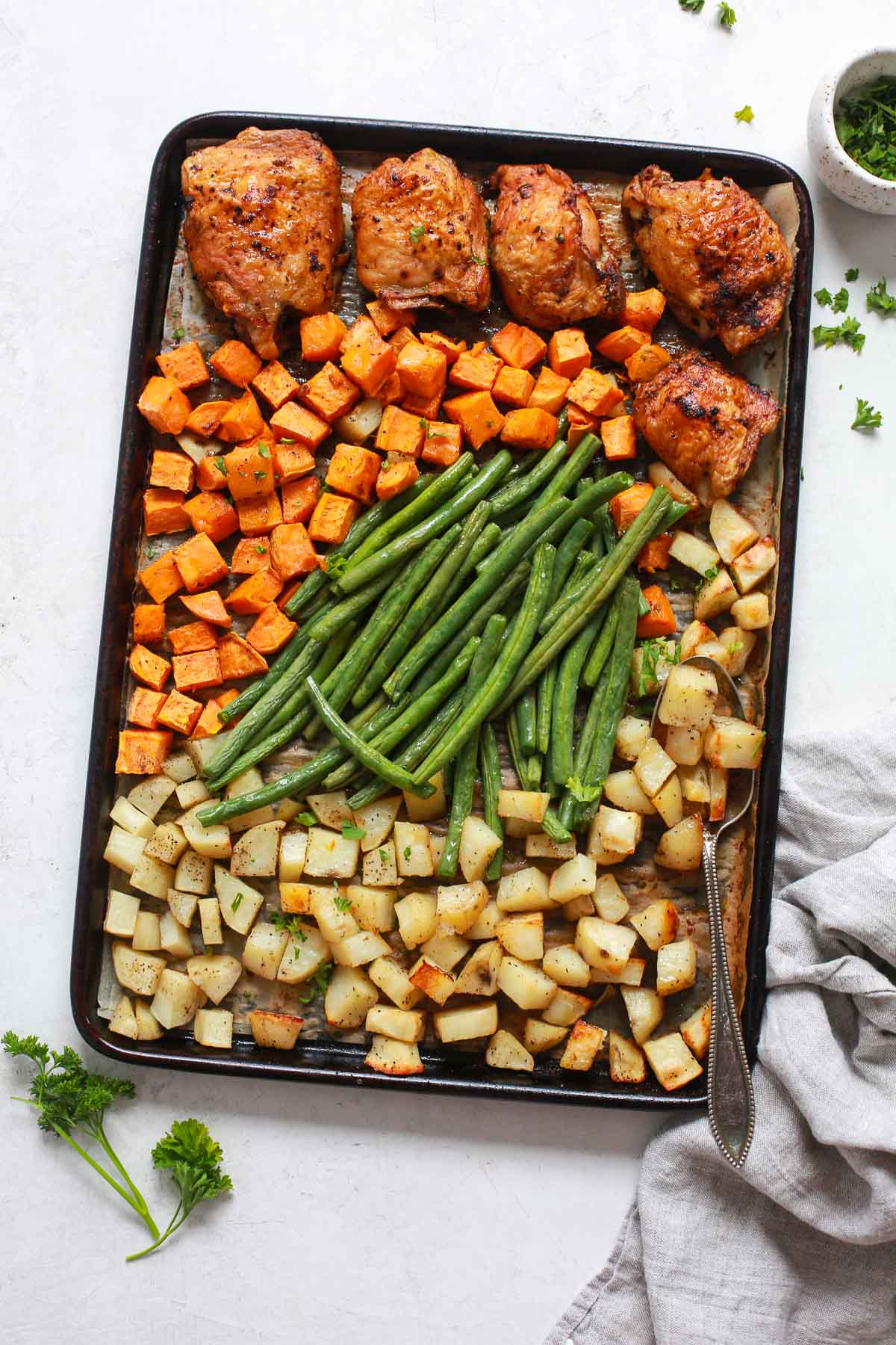 One-Pan Dinner Recipe - A sheet pan with chicken thighs, green beans, and potatoes.