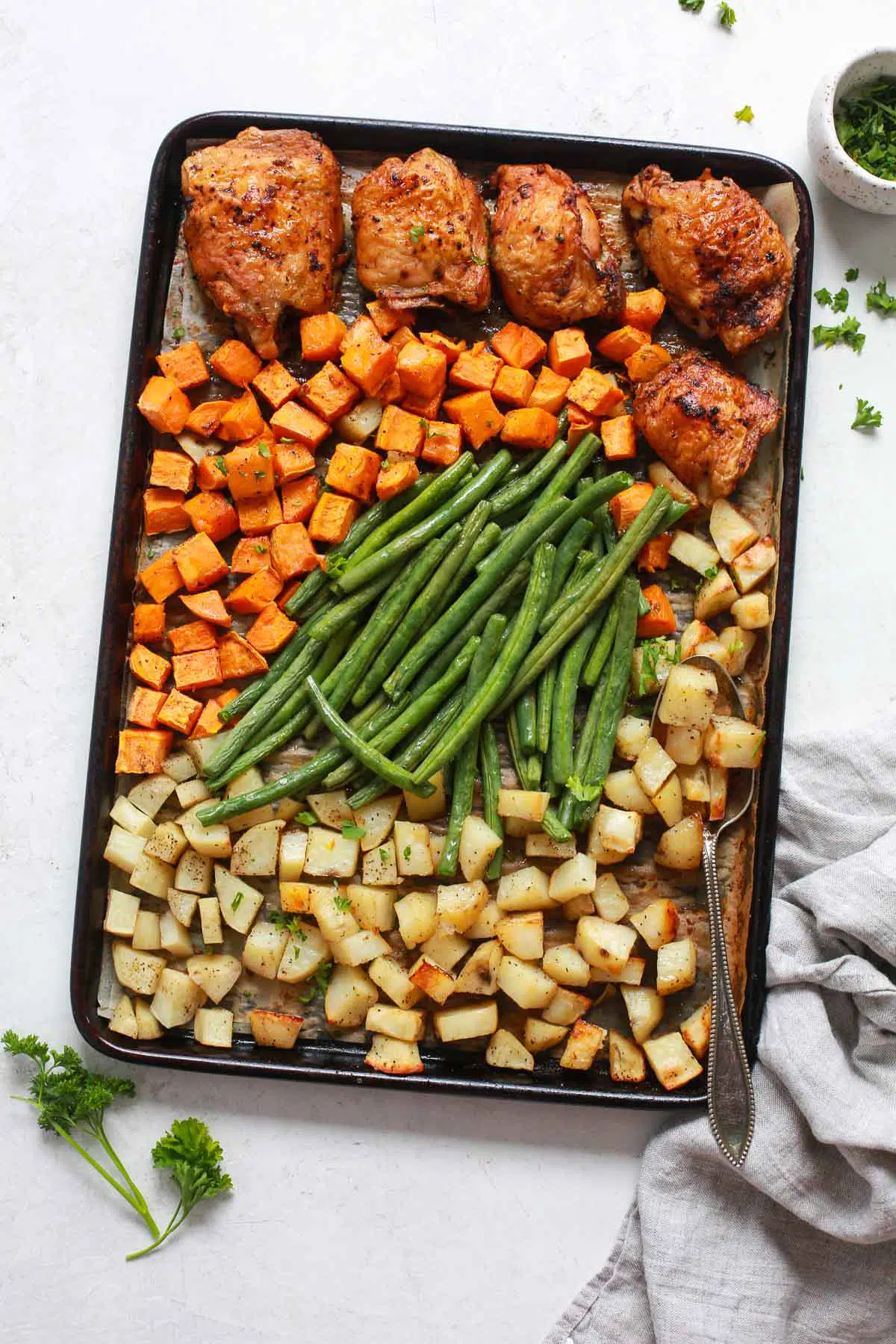 One-Pan Dinner Recipe - A sheet pan with chicken thighs, green beans, and potatoes.