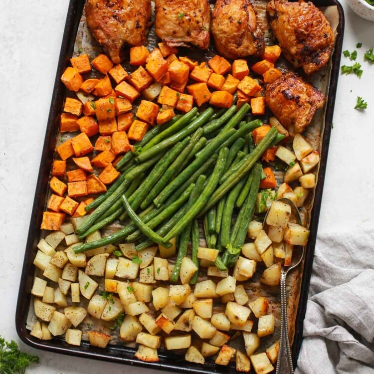 overhead view of a baking sheet containing chicken thighs and veggies