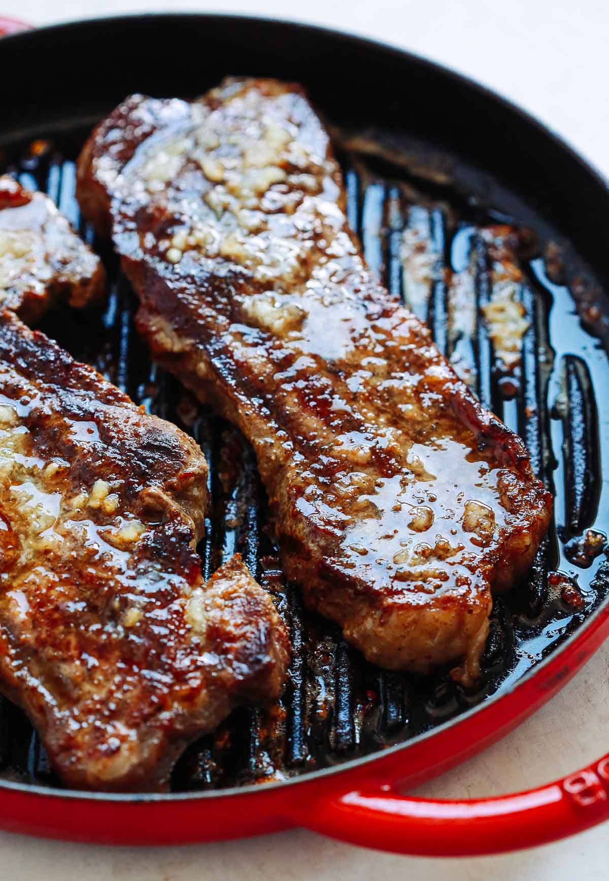 overhead photo of a garlic butter steak in a skillet 