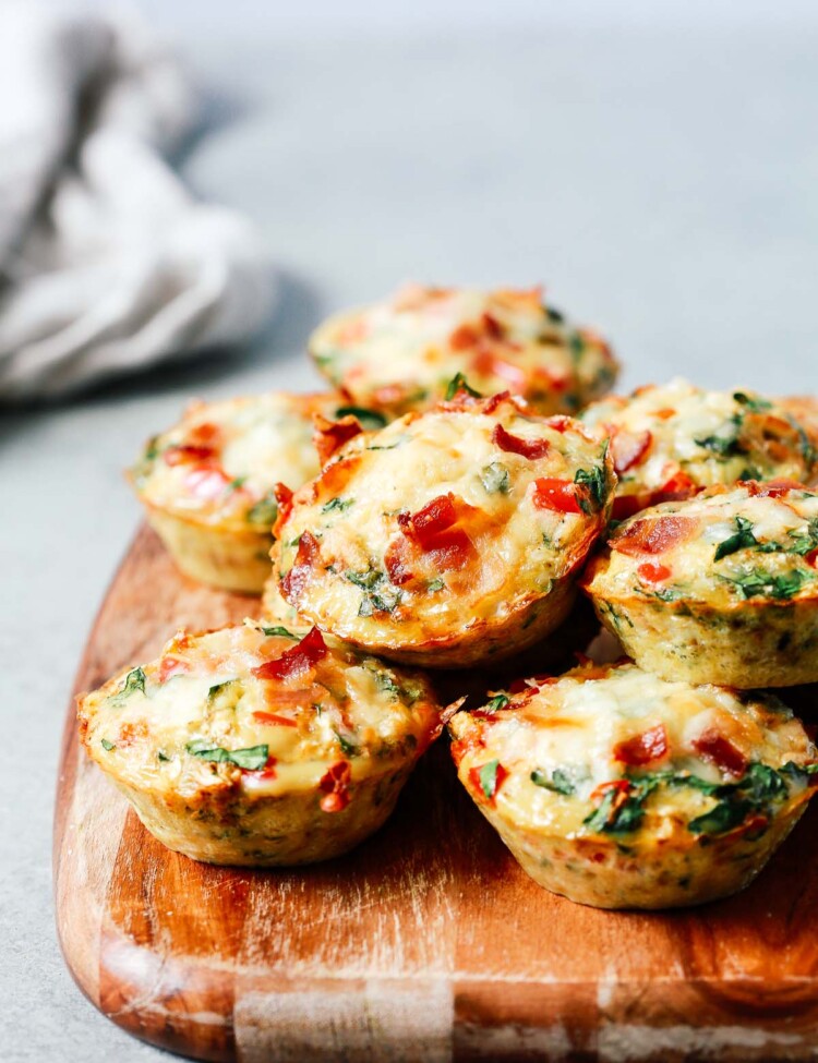 A close up of egg muffins on top of wooden serving board