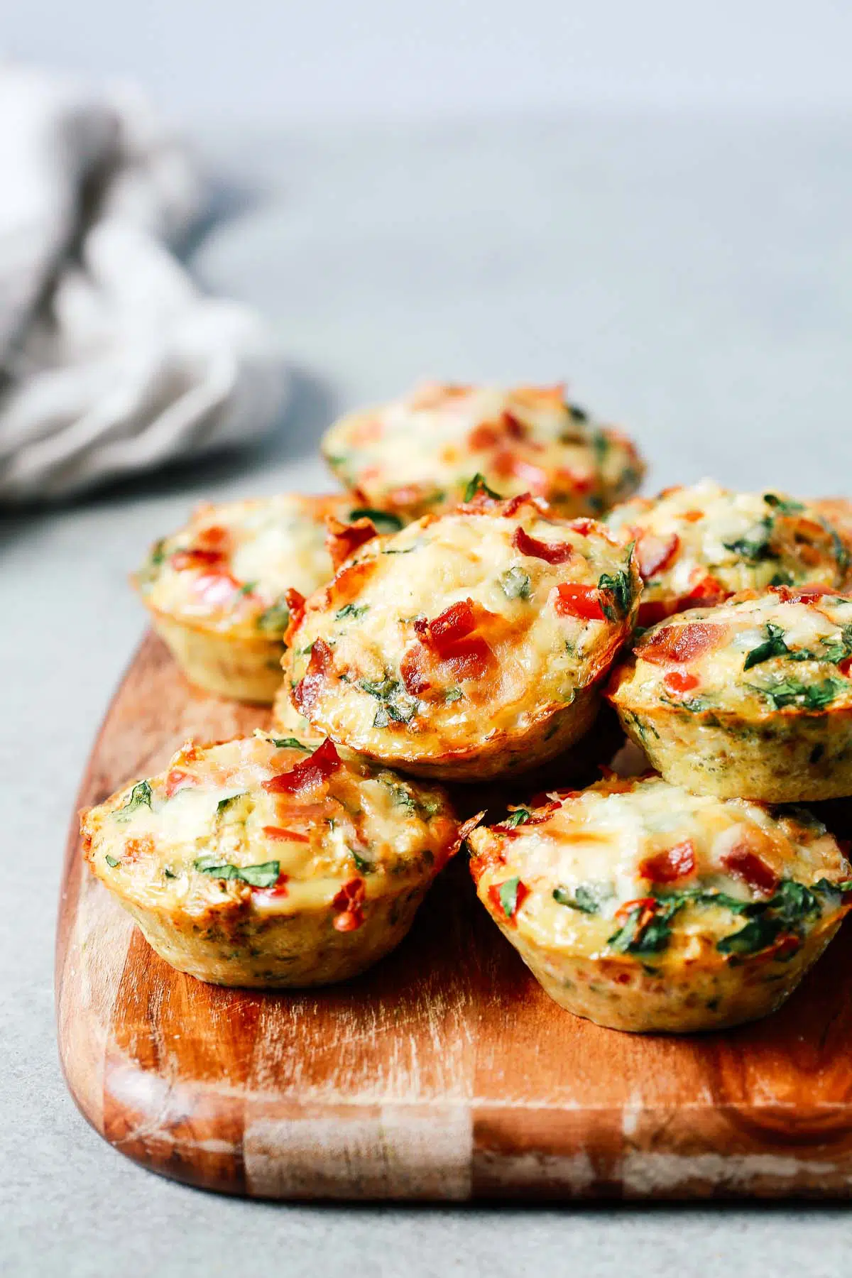 several breakfast egg muffins on a wooden serving board