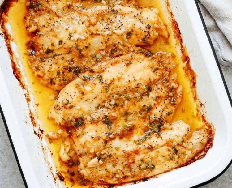 overhead view of a baked tilapia on a baking sheet