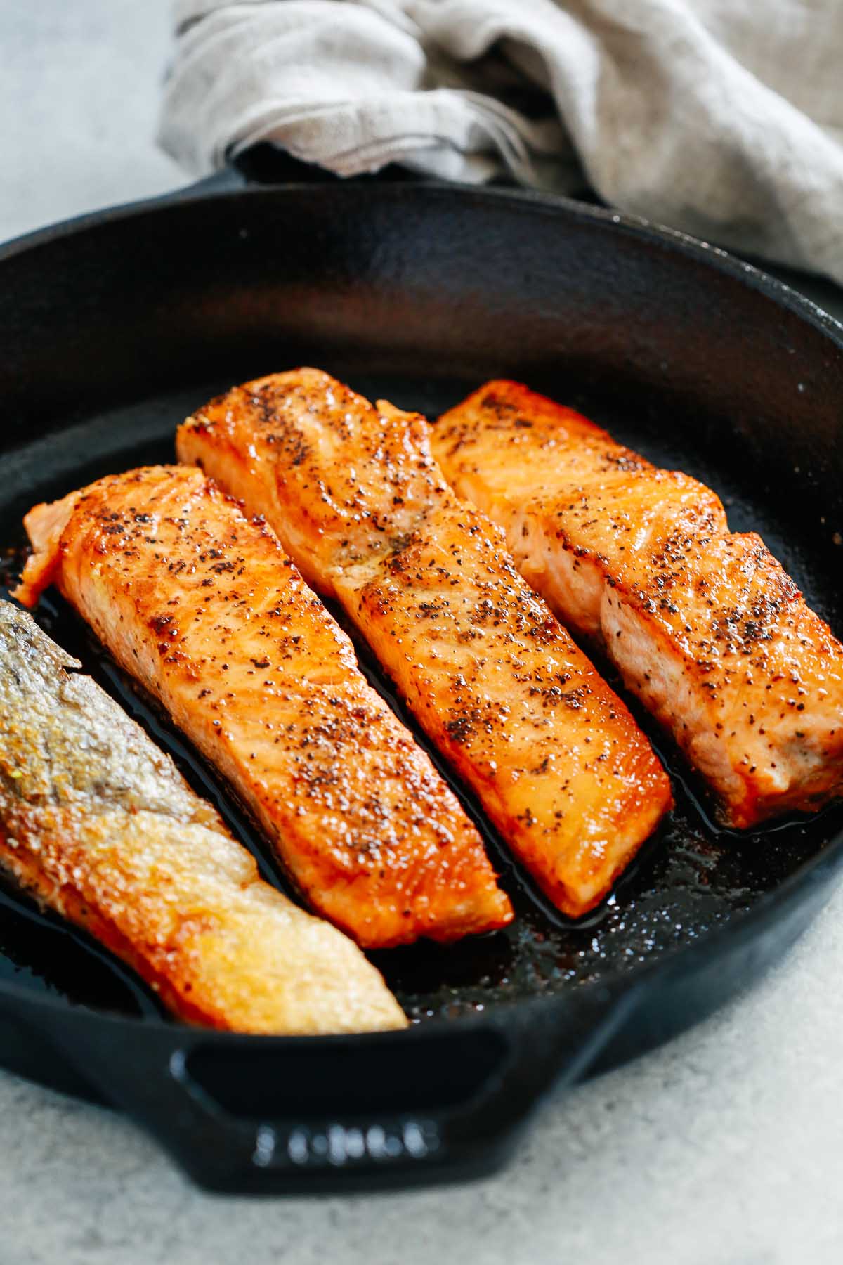overhead view of a cast iron skillet containing pan seared salmon