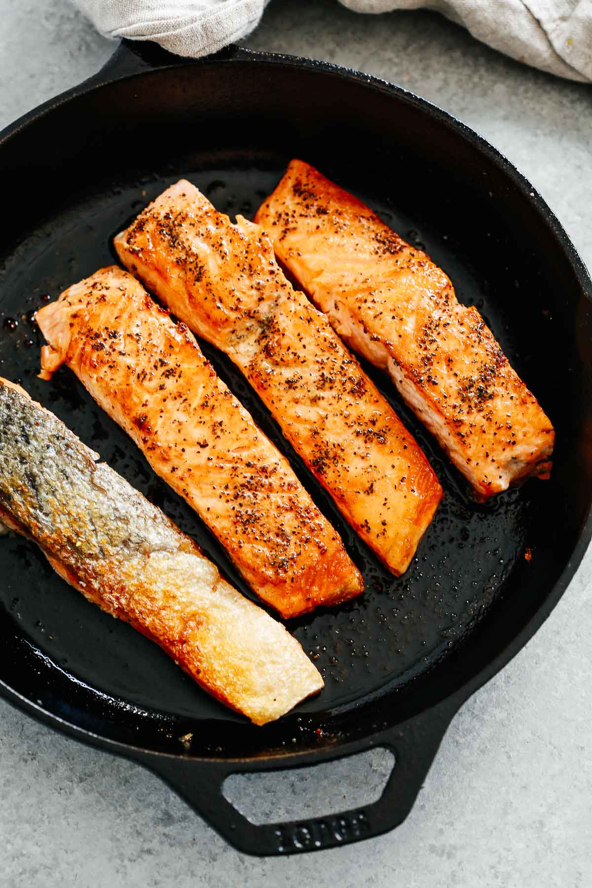 4 pieces of fish in black iron skillet
