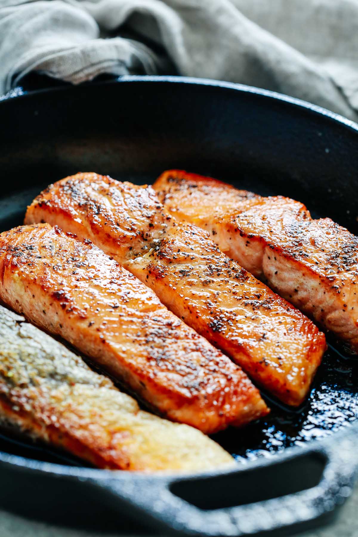 4 pan seared salmon fillets in a cast iron skillet