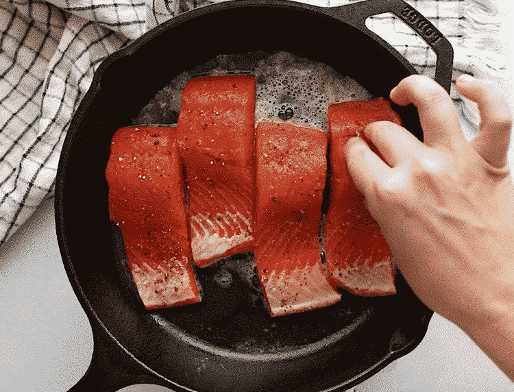 close up of filet salmon in a cast iron skillet