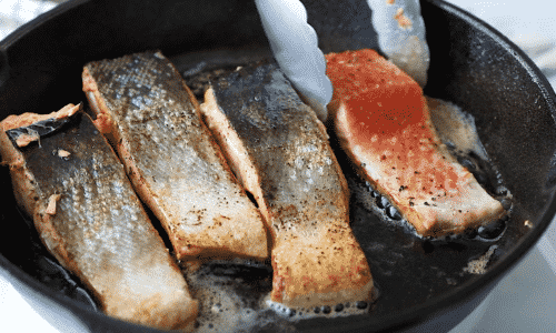 close up of filet salmon (skin side up) in a cast iron skillet