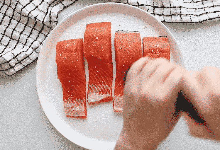 close up of raw filet salmon on a white plate