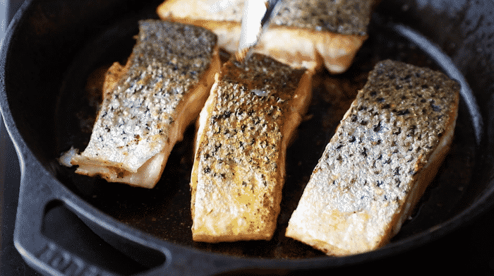 close up of crispy skin salmon inside of a cast iron skillet