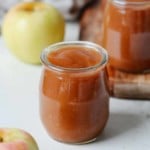 A close up of a small glass containing slow cooker apple sauce