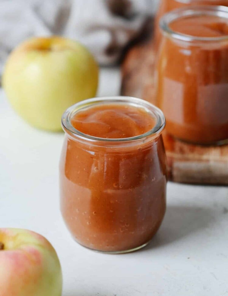 A close up of a small glass containing slow cooker apple sauce