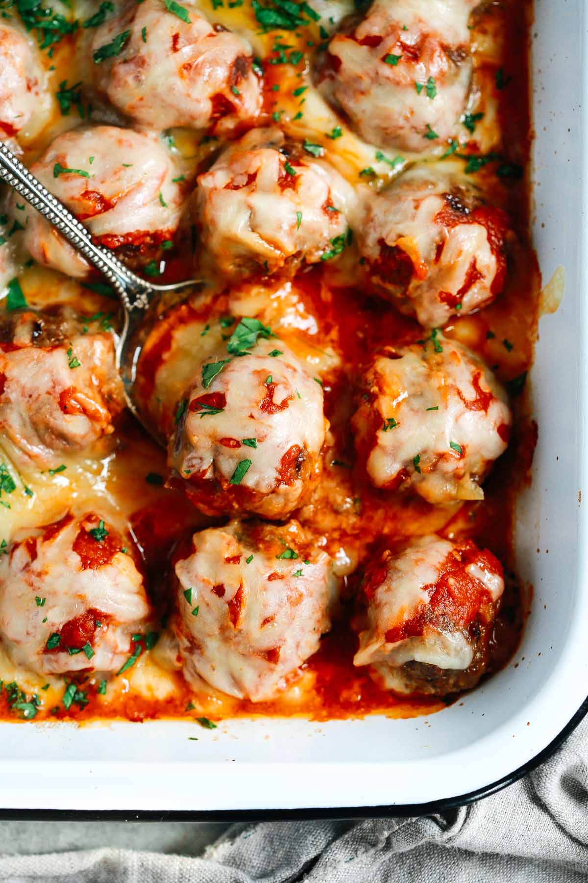 Close up of Baked Meatballs Casserole with a spoon lifting one meatball 