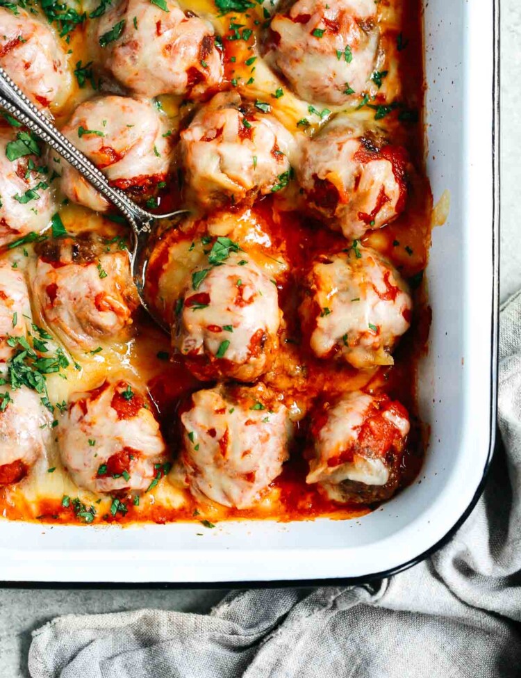 Close up of Baked Meatballs Casserole with a spoon lifting one meatball