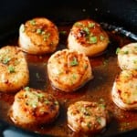 golden pan seared garlic butter scallops in a cast iron
