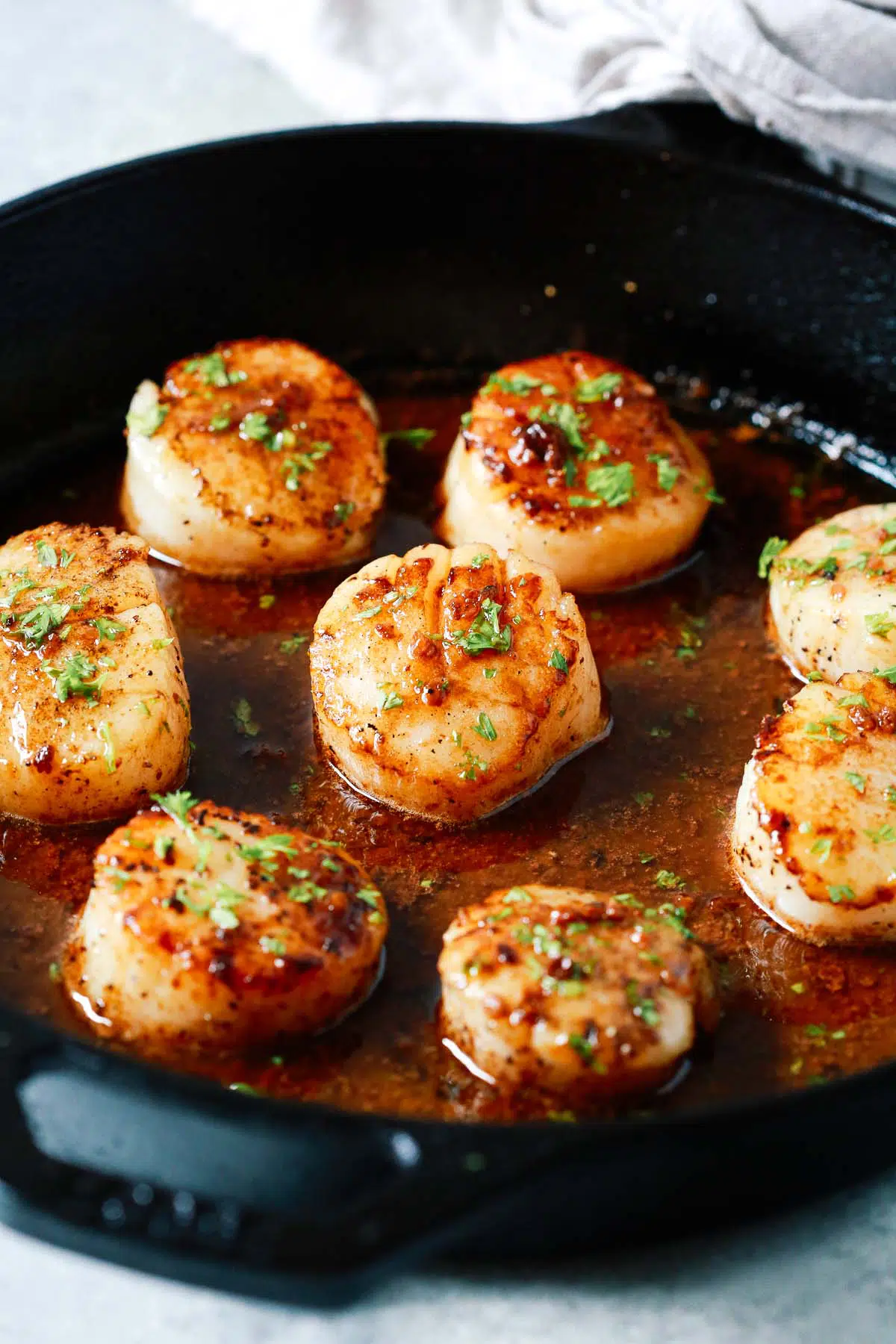 golden pan seared garlic butter scallops in a cast iron 