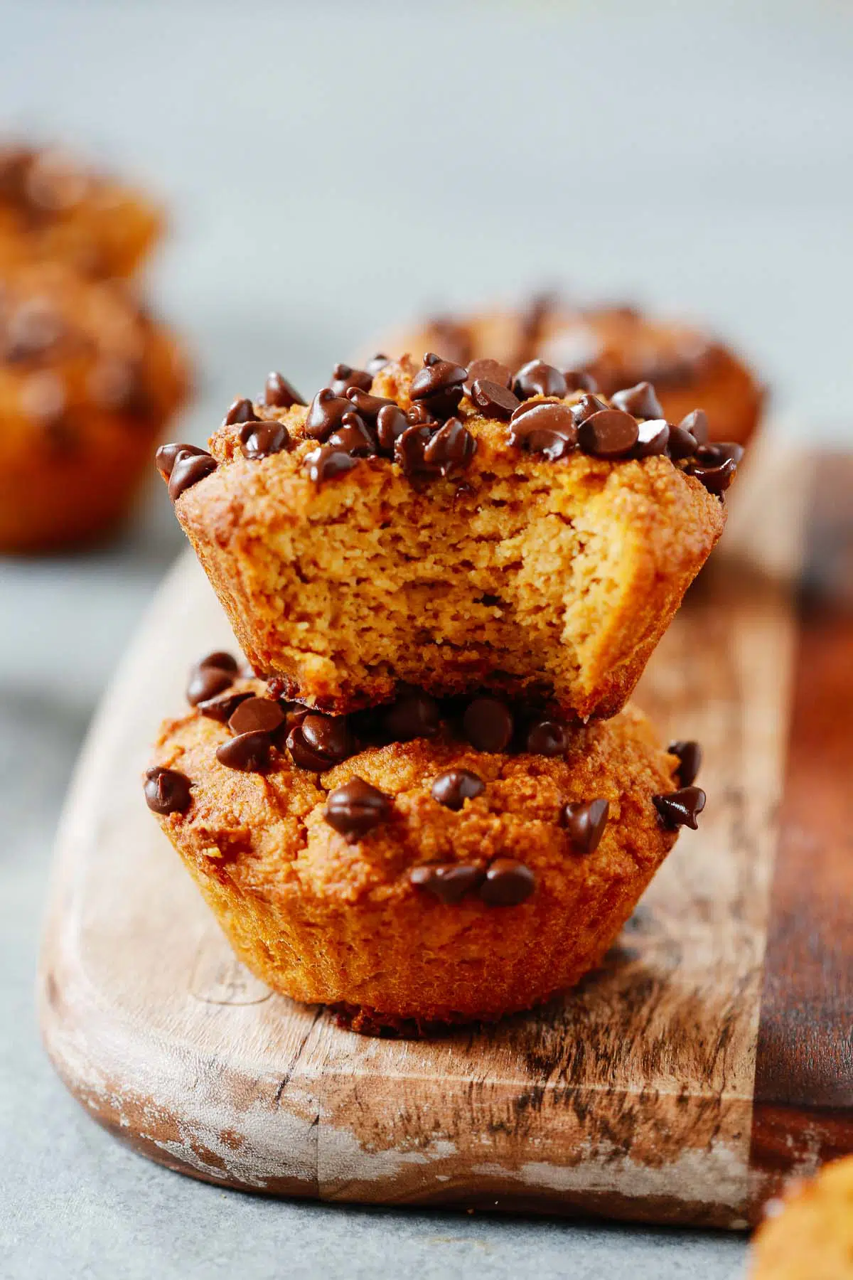 two healthy pumpkin chocolate chip muffins stacked on top of each other.