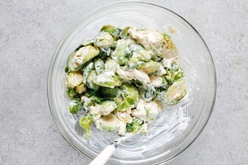 brussels sprouts with cheese mixture in a glass bowl.