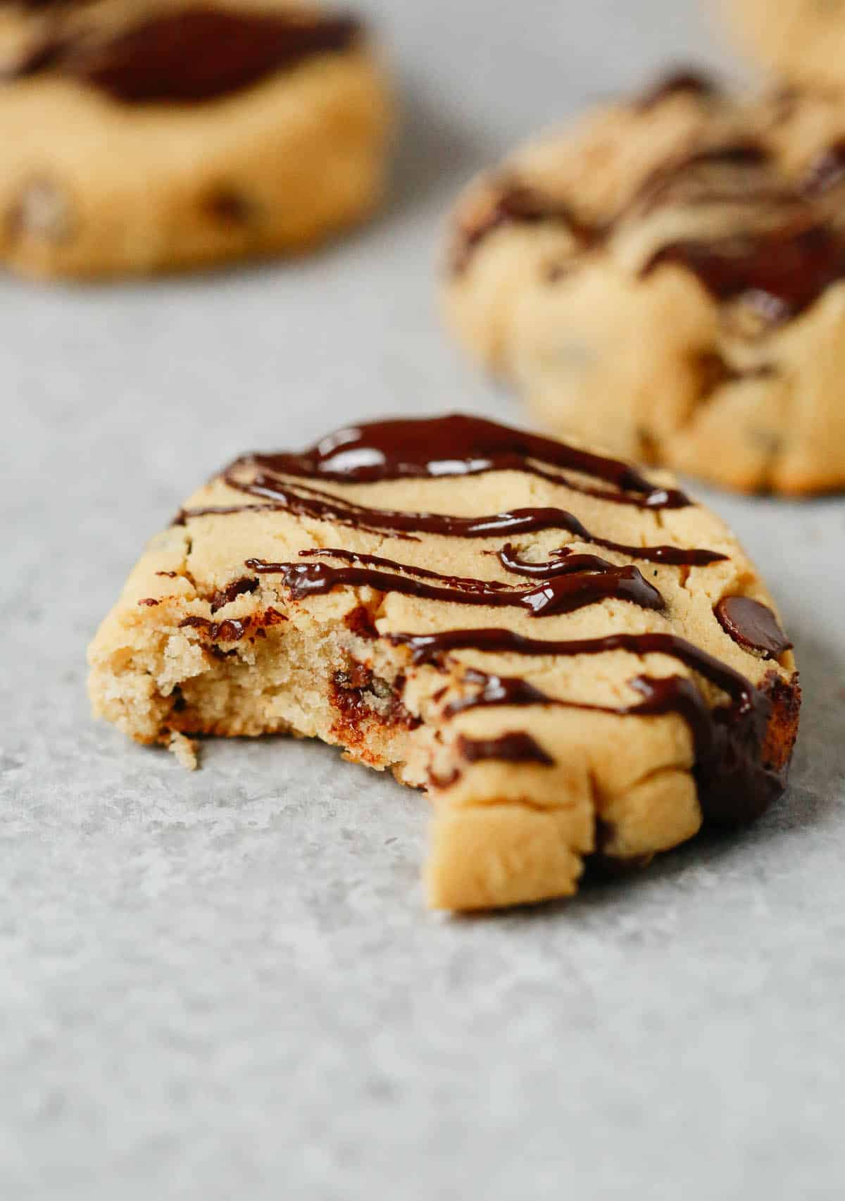 Close up of a coconut flour chocolate chip cookie with a bite taken out of it. 