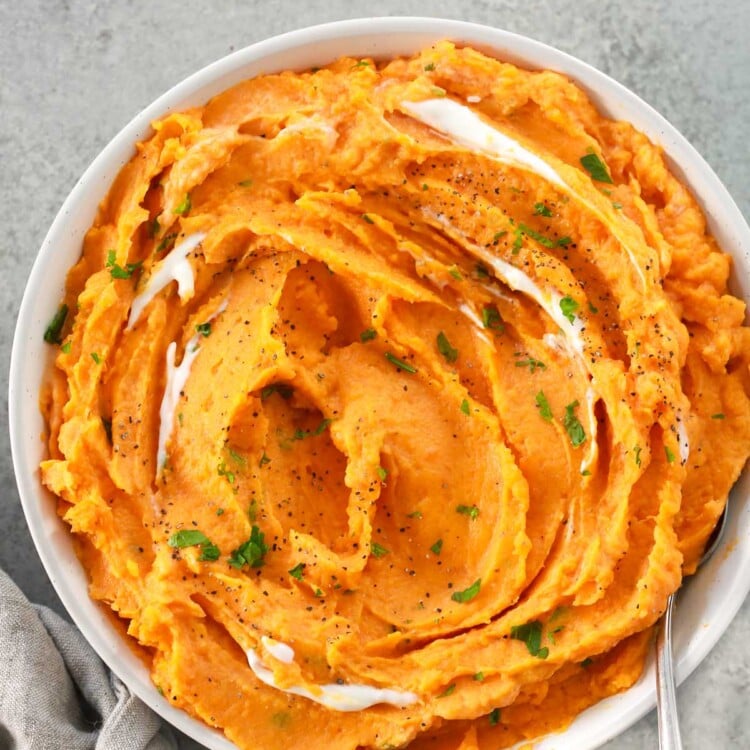 Overhead image of creamy savory mashed sweet potatoes in a white bowl.