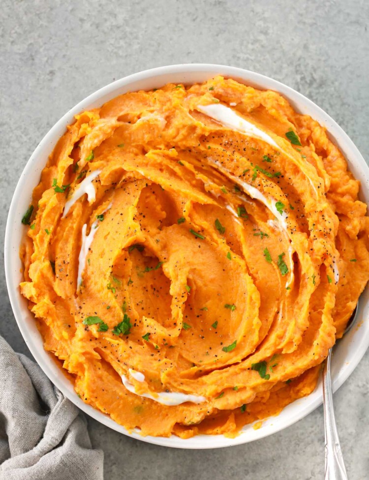 Overhead image of creamy savory mashed sweet potatoes in a white bowl.