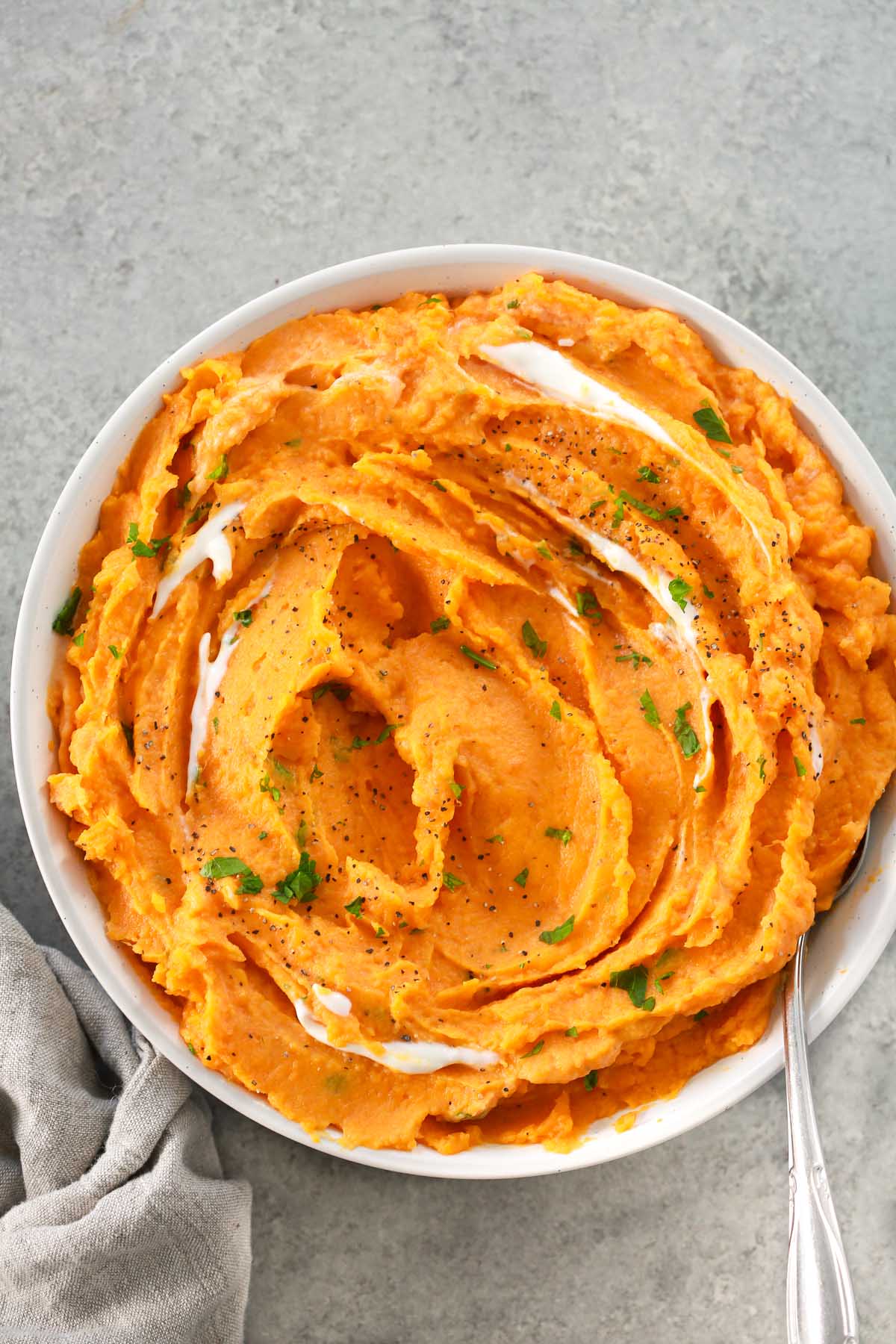 Overhead image of creamy savory mashed sweet potatoes in a white bowl.