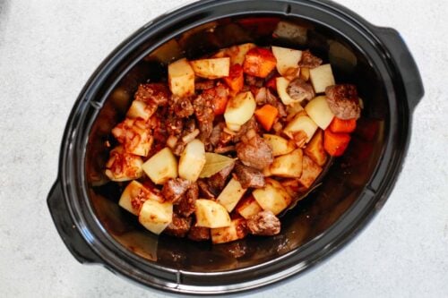 Healthy slow cooker beef stew inside of a black slow cooker.