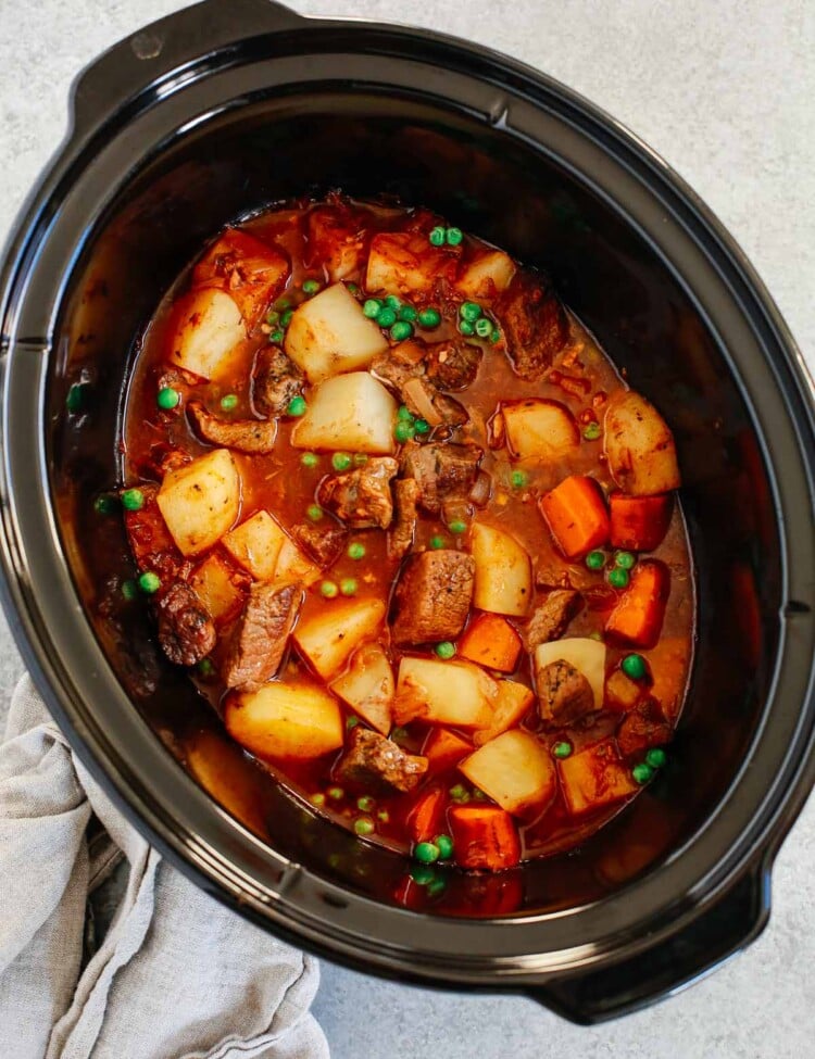 Healthy slow cooker beef stew inside of a black slow cooker.