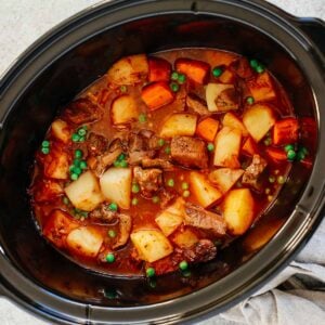 Healthy slow cooker beef stew inside of a black slow cooker.