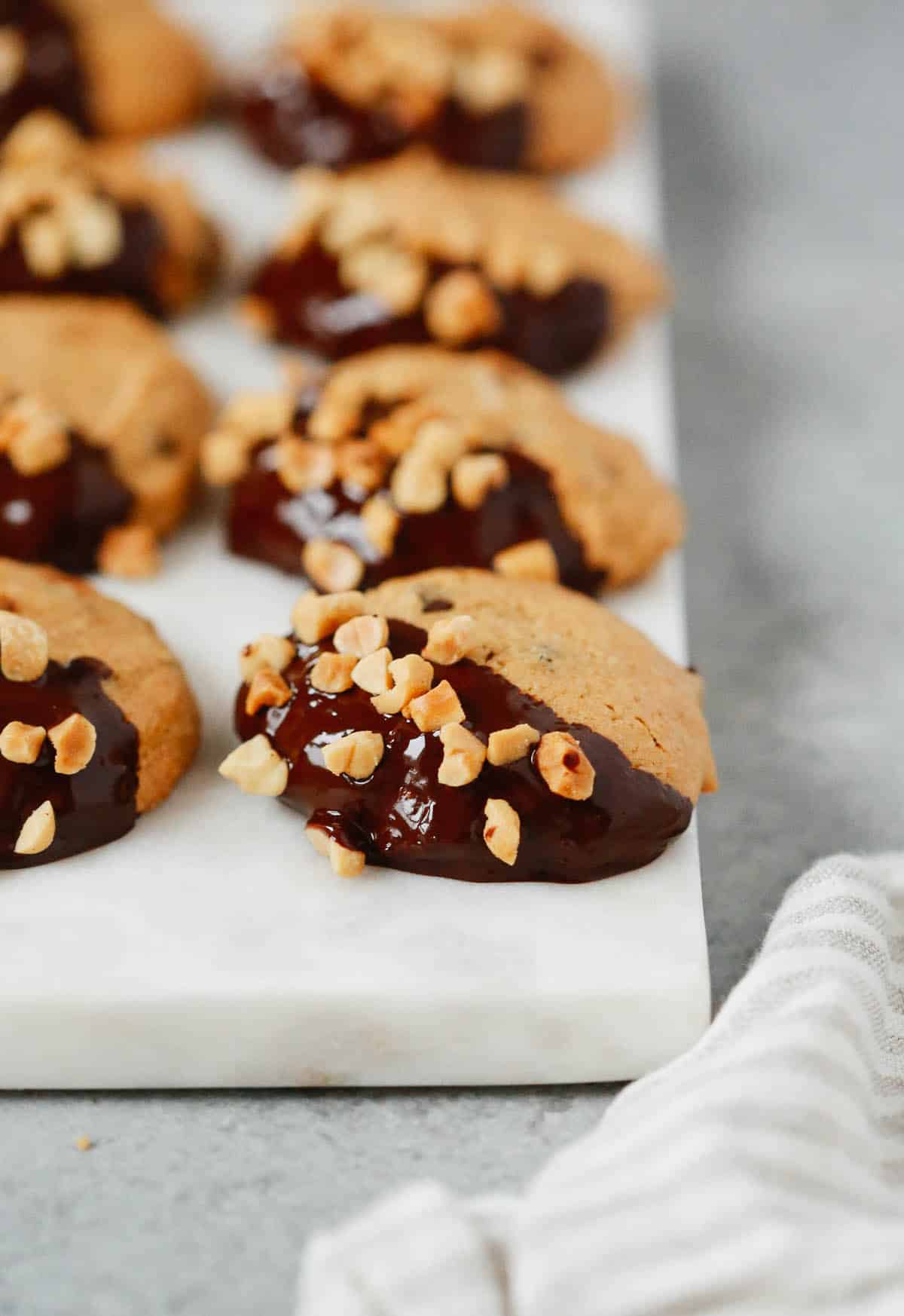 Close up of a low-carb peanut butter cookies dipped in chocolate and topped with chopped peanuts. 