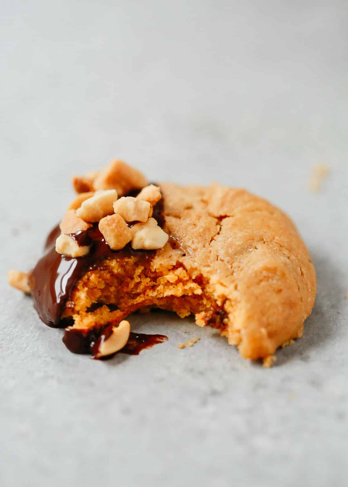 Close up of a peanut butter cookie with a bite taken out.