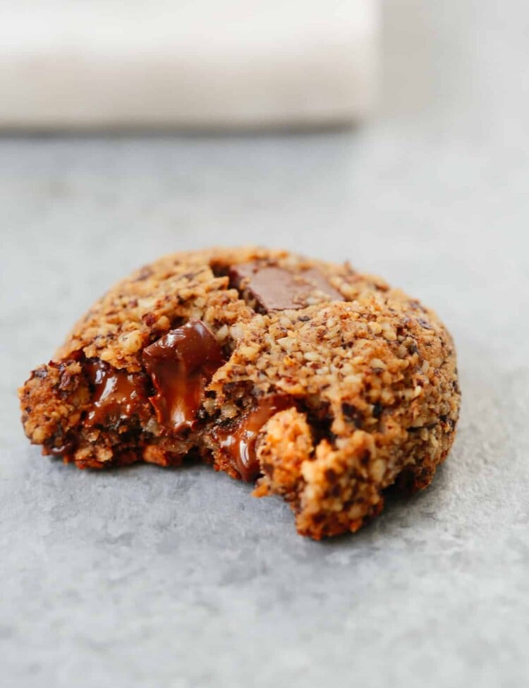 A photo of Chocolate Chunk Hazelnut Cookies with a bite taken out of it.