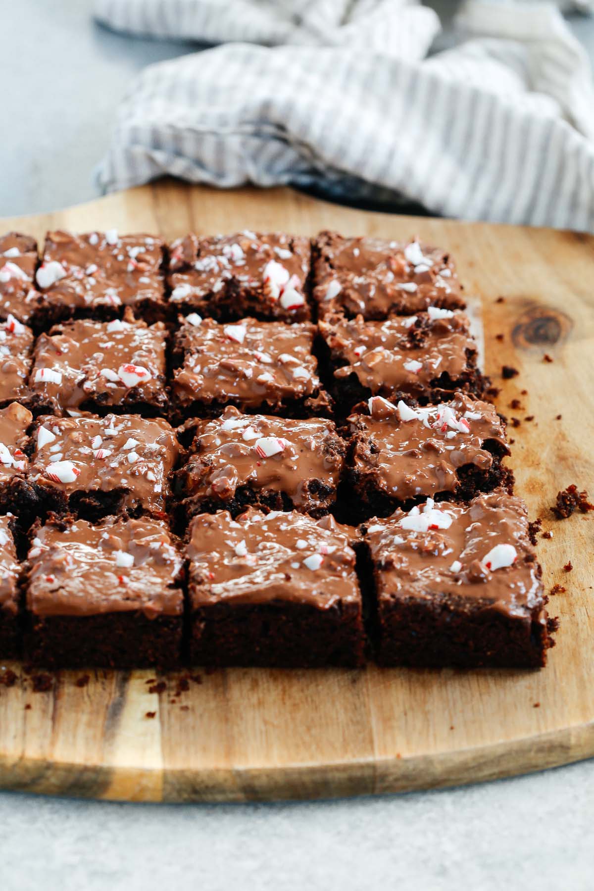 Angled photo of multiple gluten-free Peppermint Brownies cut on a serving board.