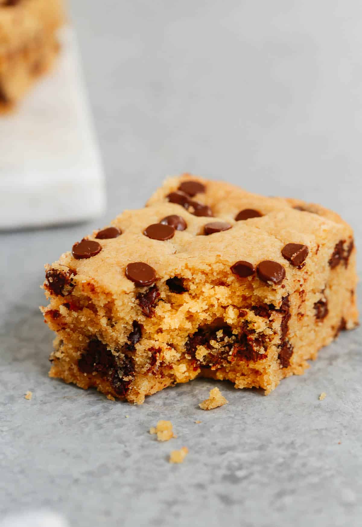 Close up of a cookie bar with a bite taken out of it. 