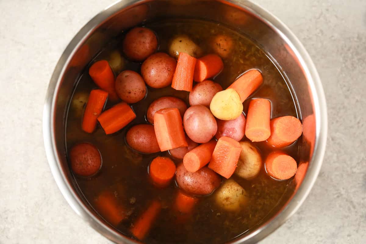 Vegetables being added to the Instant Pot.