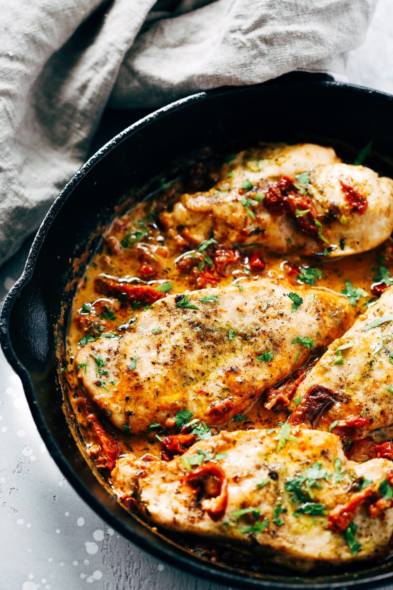 overhead view of a white skillet containing Chicken breast and Cream