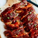 A close up of a baked ribs on a wooden cutting board