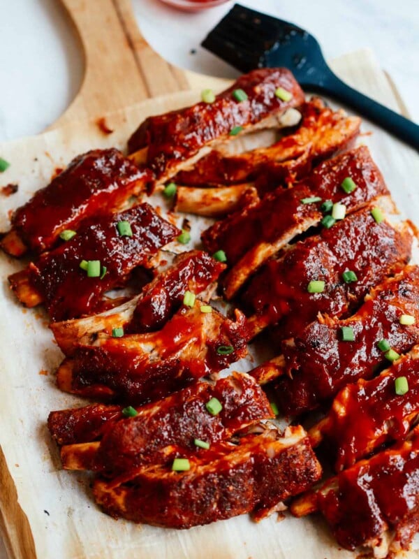 A close up of a baked ribs on a wooden cutting board