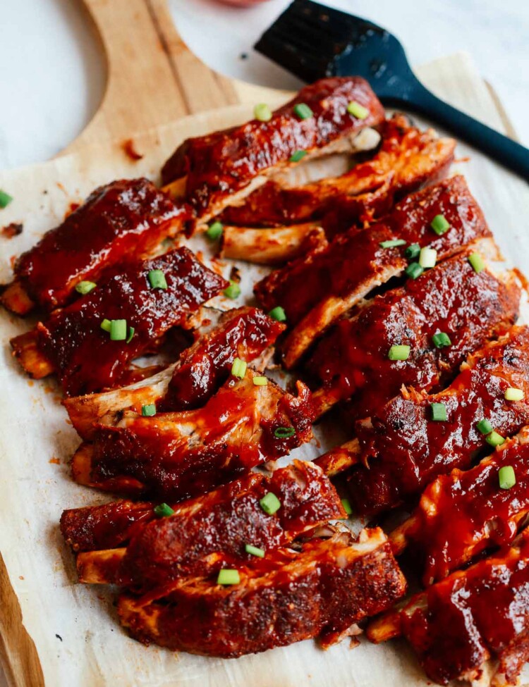 A close up of a baked ribs on a wooden cutting board