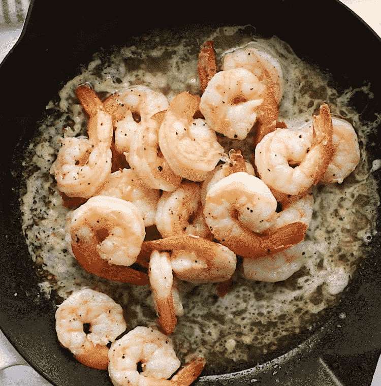 overhead view of a cast iron skillet containing shrimp