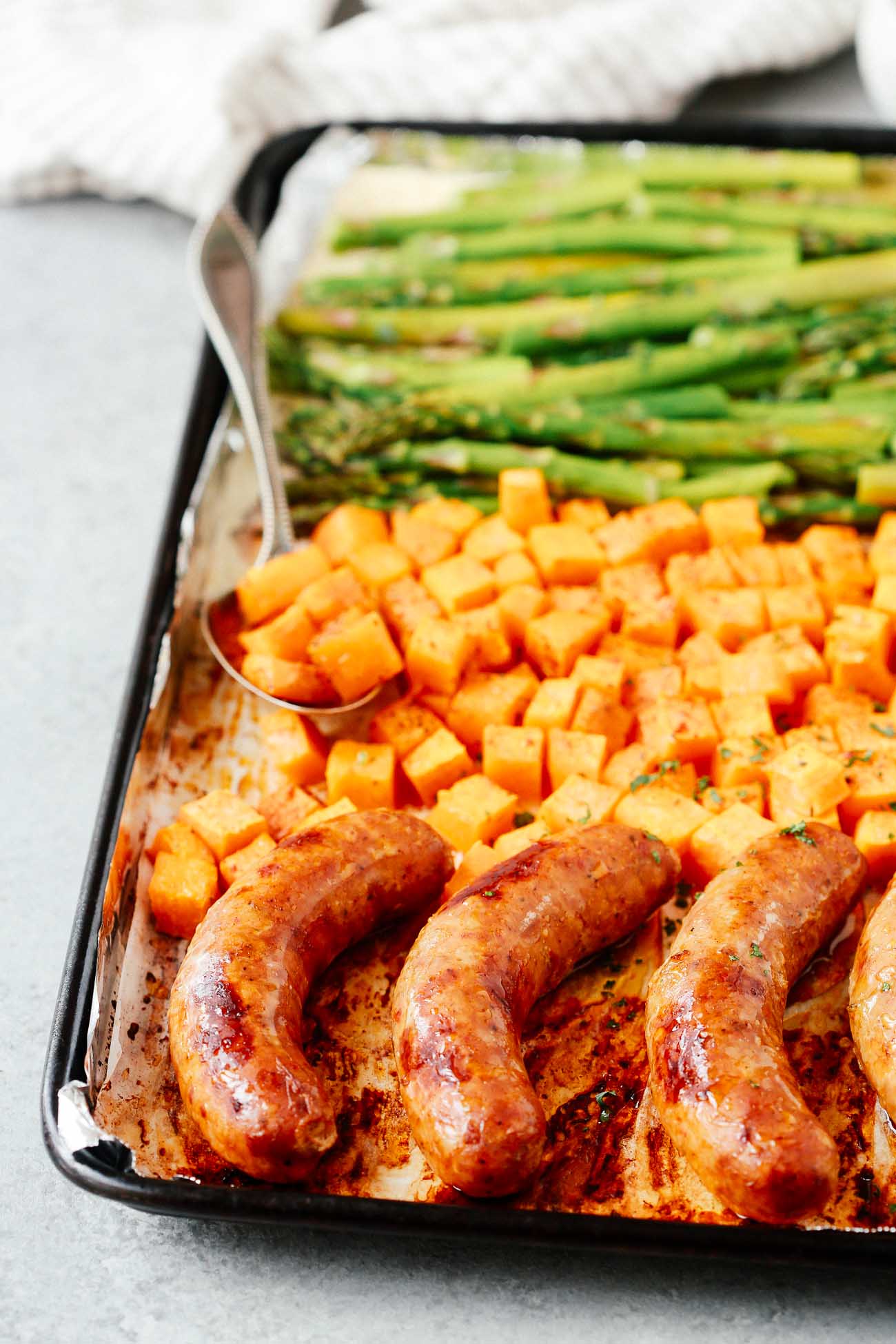 Sheet pan with sausage, sweet potatoes, and asparagus.