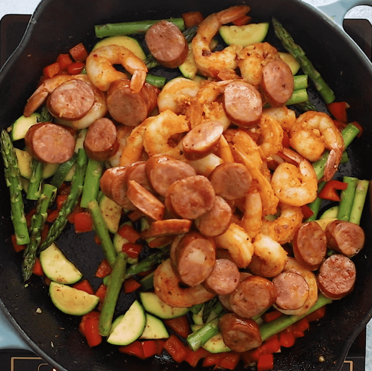 overhead view of a cast iron skillet containing shrimp and sausage