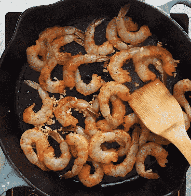 overhead view of cast iron skillet containing shrimp and sausage