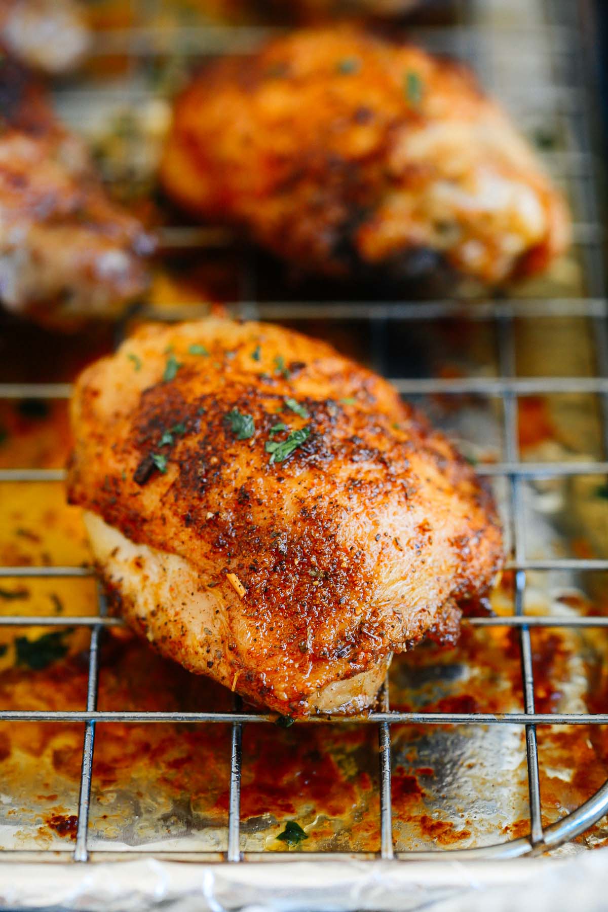 Close up of crispy chicken thighs on a rack.