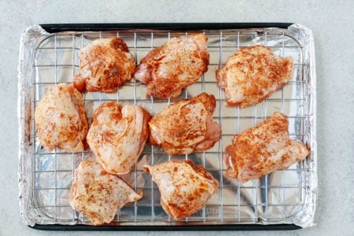 overhead view of raw chicken thighs on a rack