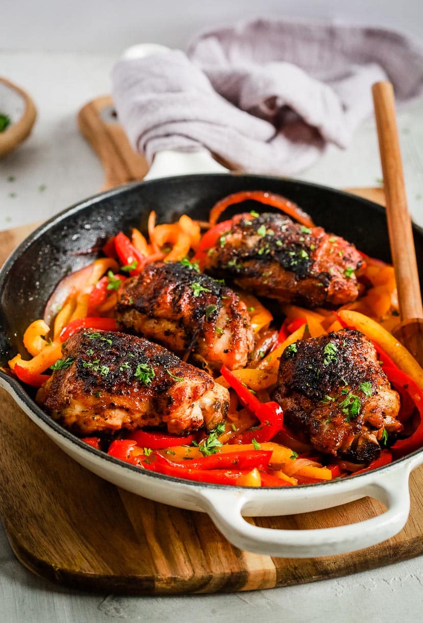 close up of a white skillet containing Chicken and Peppers